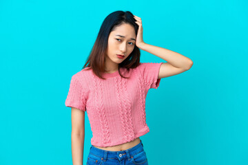 Young Vietnamese woman isolated on blue background with an expression of frustration and not understanding