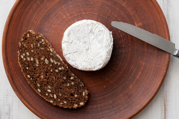 Grain bread and blue cheese on a brown clay plate. Cooking snacks.