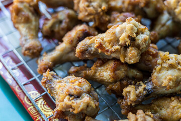 Plenty of pieces of chicken drumsticks are piled up on the grill.