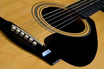 Fototapeta premium The bridge and strings of and acustic guitar