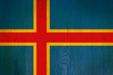 The flag of Aland Islands on a grunge wooden background.
