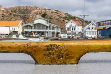 Lovely wooden detail from wooden boat moored in the bay with blurred buildings in background