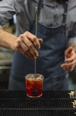 Bartender making cocktails with bar spoon