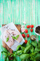 Raw chicken breast marinated for baking on a wooden board, copy space, top view