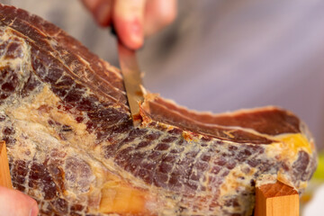 Man cuts mini ham with a special knife.