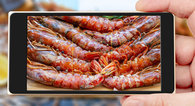 Prawn on smartphone screen.Tiger chrimp. Selling seafood in a supermarket. Delicious gourmet shrimp for the festive table.
