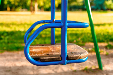 Children's swing in the park in summer at sunset. The concept of childhood