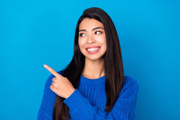 Photo portrait young girl curious showing finger empty space isolated on vivid blue color background