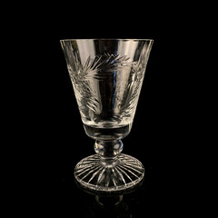 vintage crystal goblet with carvings on a black background. antique glass goblet