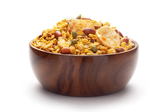 Close-Up of Hot spicy Nav Ratan snacks In hand-made (handcrafted) wooden bowl, made with red chili, peanuts. Indian spicy snacks (Namkeen),
