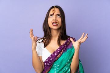 Fototapeta na wymiar Young Indian woman isolated on purple background stressed overwhelmed