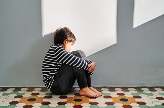 Frustrated child sitting alone in room