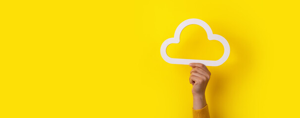 Cloud computing concept, hand holding cloud over yellow background, cloud storage, panoramic mock-up - obrazy, fototapety, plakaty