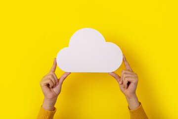 Cloud computing concept, hands holding cloud over yellow background, cloud storage