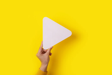 play symbol in hand over yellow background, multimedia concept