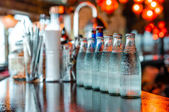 Glass bottles with cold water on counter in bar