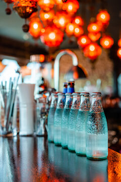 Glass bottles with cold water on counter in bar