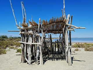 Une cabane en bois flotté en bord de mer