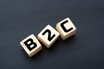 Motivational Words: B2C in 3d wooden alphabet letters on a black background with copy space. Business-to-consumer, concept