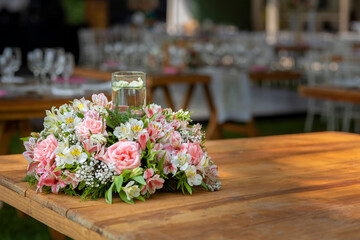Arreglo floral sobre una mesa de madera en un evento social en México
