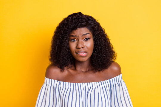 Portrait of attractive worried miserable girl bad news reaction biting lips isolated over bright yellow color background