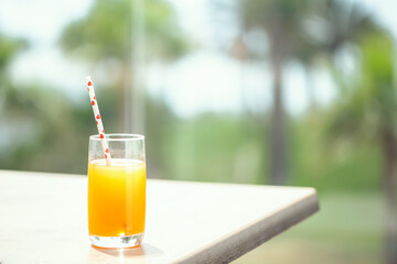 Orange juice on the table in the palm tree forest. Summer vocation. Concept