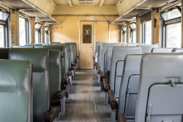 Fototapeta na wymiar Interior of a passenger train with empty seats. An old train car from the inside. Russian Railways.