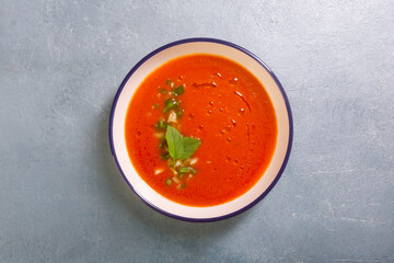 Plate of gazpacho made from tomato with garlic and basil leaves copy space
