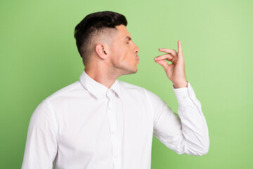 Photo of funny funky young gentleman wear white shirt trying delicious food isolated green color...