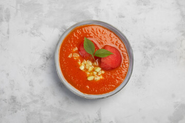 Traditional Spanish dish gazpacho with watermelon. Cold gazpacho in a plate on a gray background