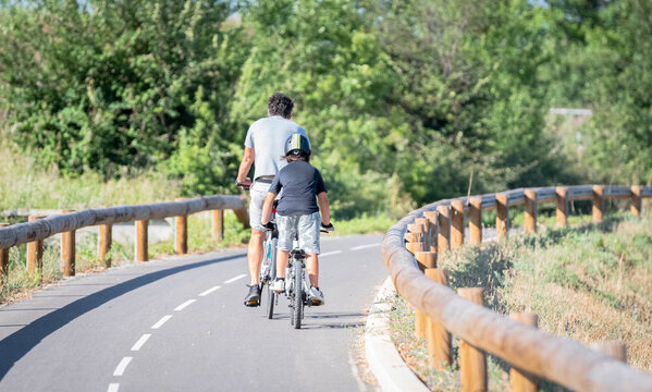 Vue d'un homme et un enfant sur une piste cyclable en v&eacute;lo.
