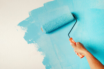Roller Brush Painting, Worker painting on surface wall  Painting apartment, renovating with blue...