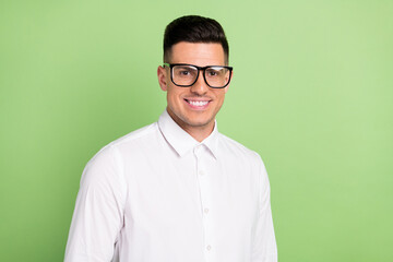 Photo of cute charming young gentleman wear white shirt spectacles smiling isolated green color background