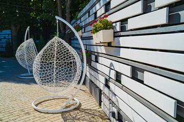 hanging chair cocoon on the frame in the yard of the house. 