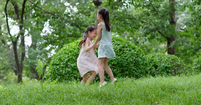Two little girls playing on grass,4K