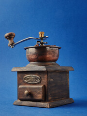 Vintage vintage retro bronze coffee Mill on a blue background with Roasted Coffee Beans