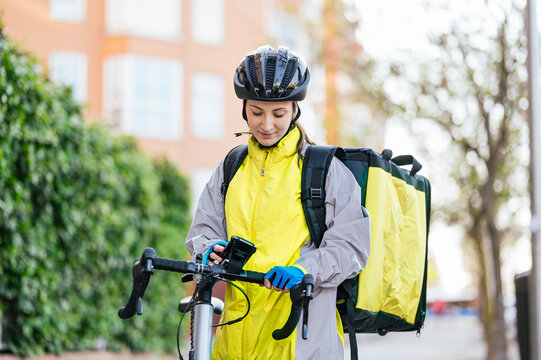 Young delivery woman using GPS map