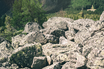 Background of stones at the top of the mountain. Gray large stones on a bright sunny day.