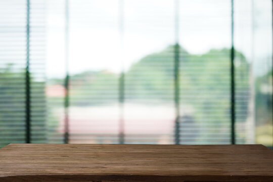 Abstract bokeh sunlight view from the window background with old wood table.	