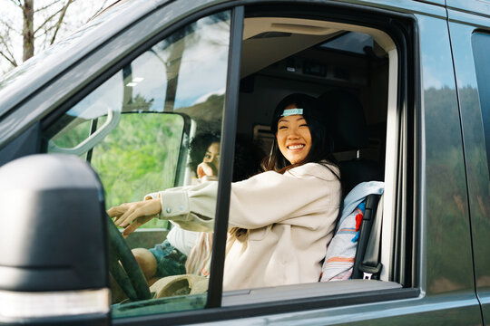 Happy diverse women traveling by camper van
