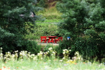 Red benches and table, tilt shift image. Summer in Germany. Selected focus.