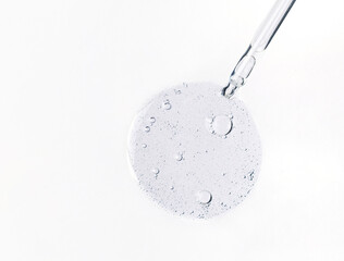 Cosmetic serum bubbles and dropper with hyaluronic acid on white background.