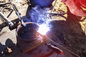 Close-up of an electric welder welds a metal structure. Welding works.