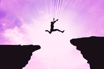 Silhouette Of A Man Jumping Over The Cliff  On Stunning  Pink Sunset background. Business Concept Idea 