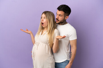 Fototapeta premium Young couple pregnant and doing surprise gesture