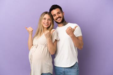 Young couple pregnant and with thumb up