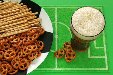 Football soccer party table with snacks and beverage. Salted pretzel and straws on big plate...
