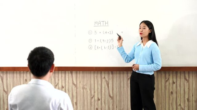 Educational concept a young smart female teacher explaining decision of hard math in a classroom 