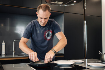 A man preparing food at home in a frying pan