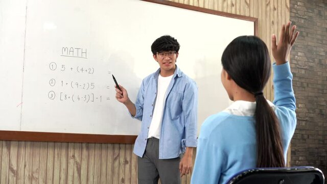 Educational concept a young smart male teacher explaining decision of hard math in a classroom